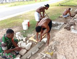 Babinsa Posramil Warsa Bantu Warga Bangun Pondasi Teras Rumah di Kampung Ammoy