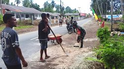 Babinsa Numfor Gotong-Royong Timbun Bahu Jalan Berlubang Bersama Warga