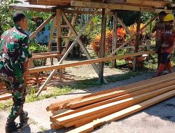 Babinsa Bantu Warga Siapkan Kayu untuk Pagar