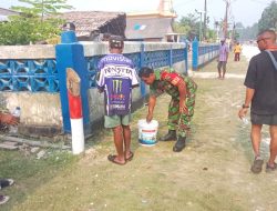 Babinsa Numfor Bantu Warga Bersihkab Pagar Gereja GKI Imanuel